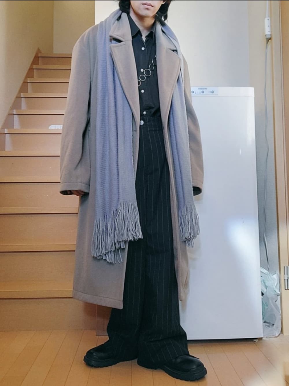 ベージュ系のチェスターコート、ブラック系のパンツ、ブラック系のシューズを着用したメンズの冬コーディネートの4枚目の写真