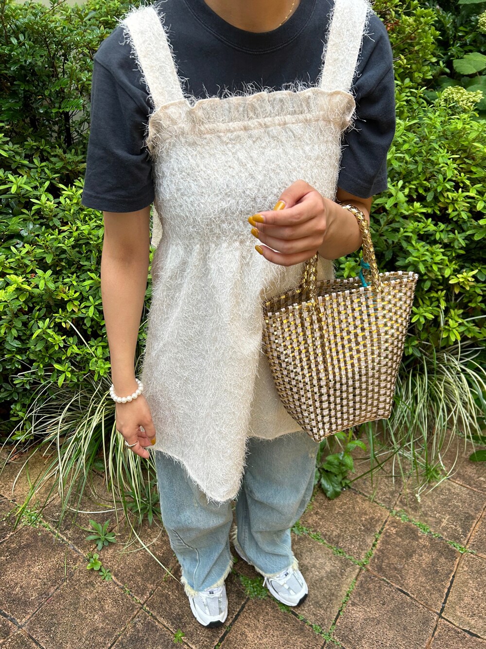 ホワイト系のトップス、グレー系のTシャツ/カットソー、ゴールド系のハンドバッグを着用したレディースの夏コーディネートの2枚目の写真