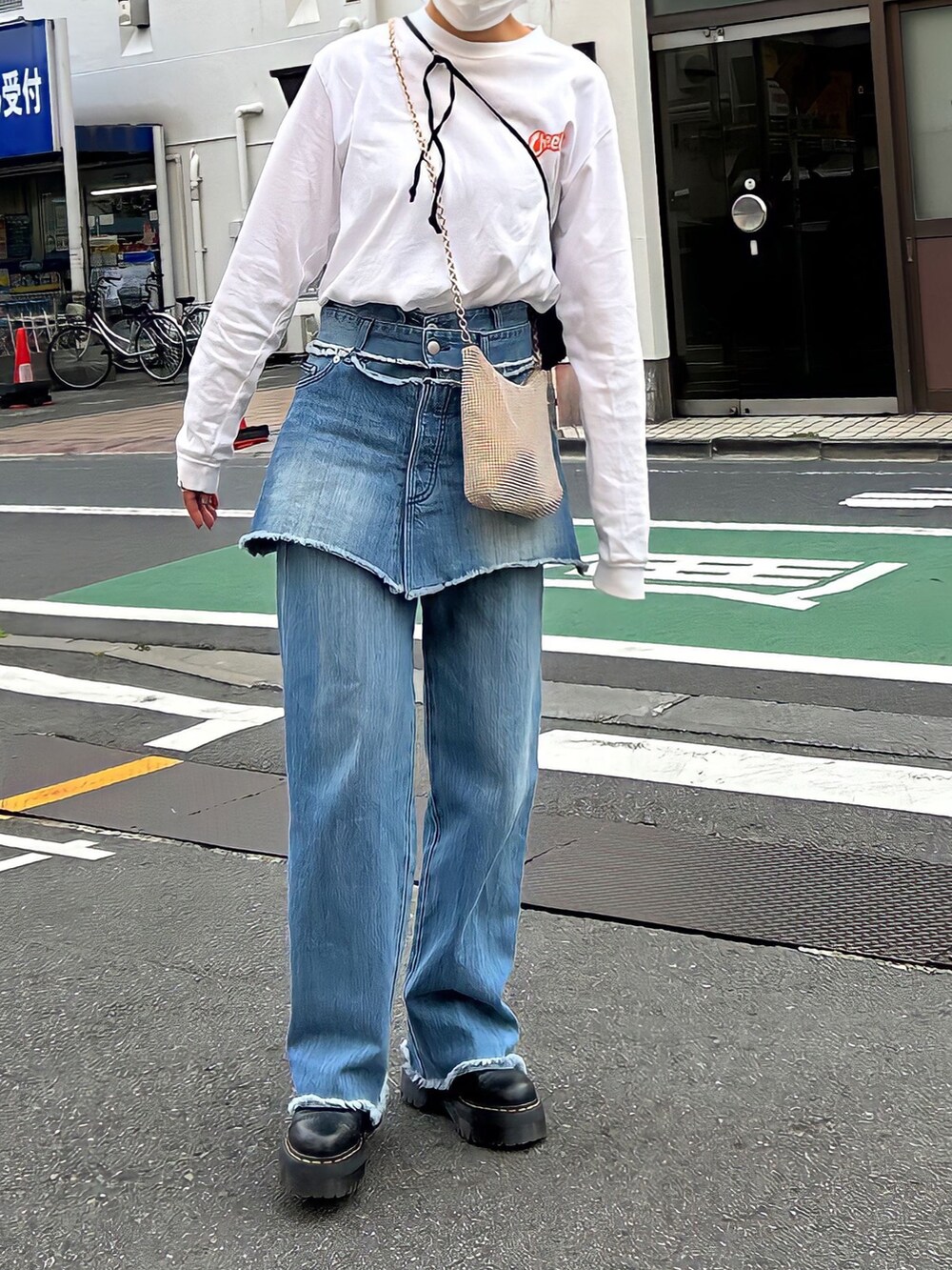 ホワイト系のTシャツ/カットソー、ブルー系のデニムパンツ、ブラック系のブーツを着用したレディースの春コーディネートの2枚目の写真