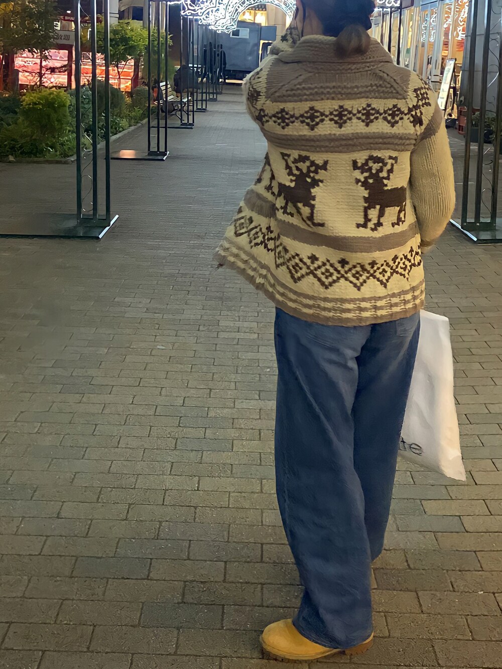 ブラウン系のハンドバッグ、ホワイト系のその他トップス、ブルー系のデニムパンツを着用したレディースの冬コーディネートの2枚目の写真