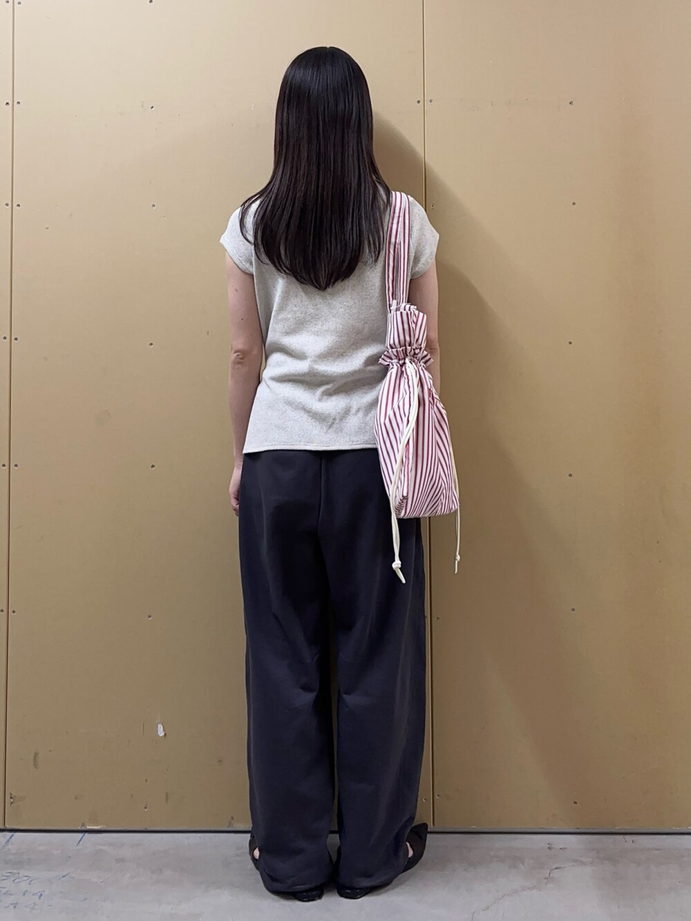 ホワイト系のTシャツ/カットソー、グレー系のその他パンツ、レッド系のトートバッグを着用したレディースの春コーディネートの3枚目の写真