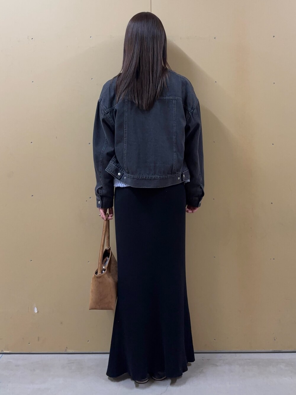 イエロー系のショルダーバッグ、ブラック系のノーカラージャケット、ブルー系のニット/セーターを着用したレディースの春コーディネートの3枚目の写真