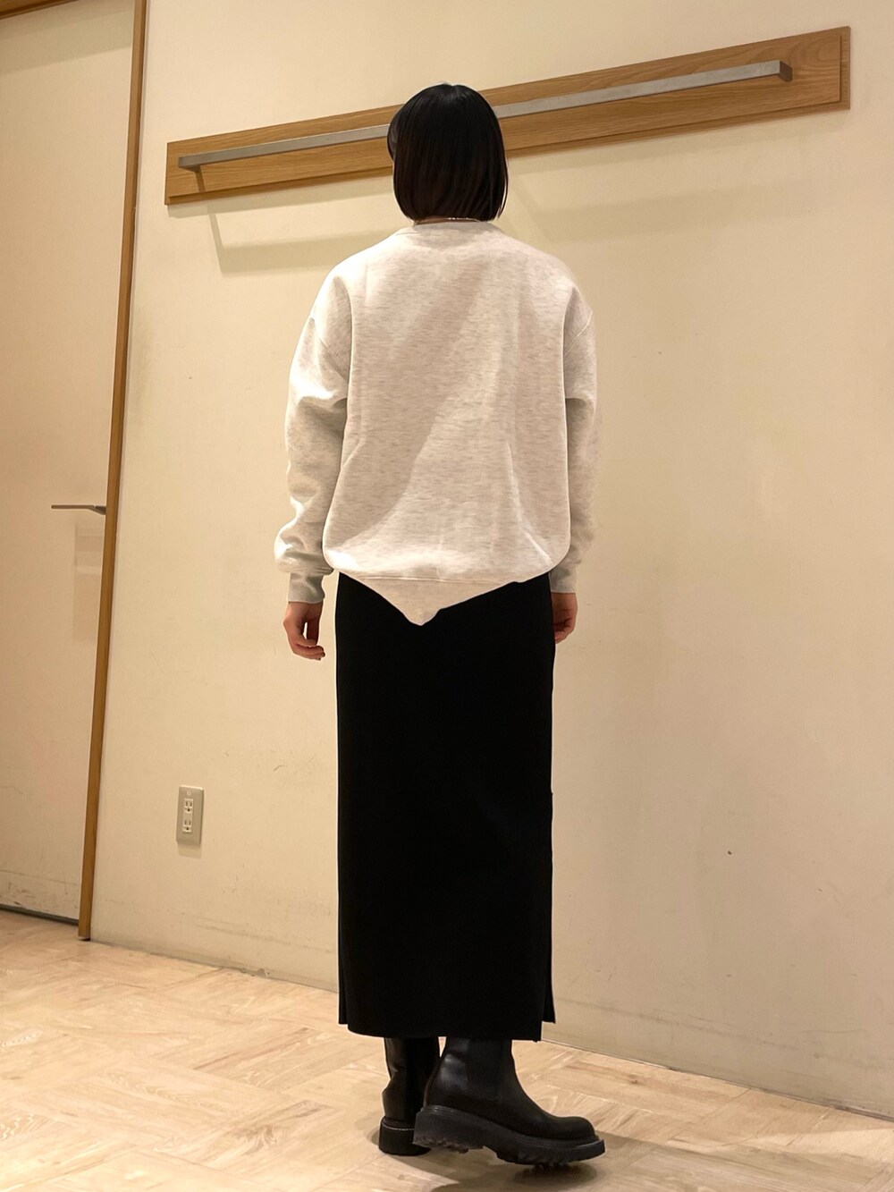 グレー系のスウェット、ブラック系のスカートを着用したレディースの冬コーディネートの2枚目の写真