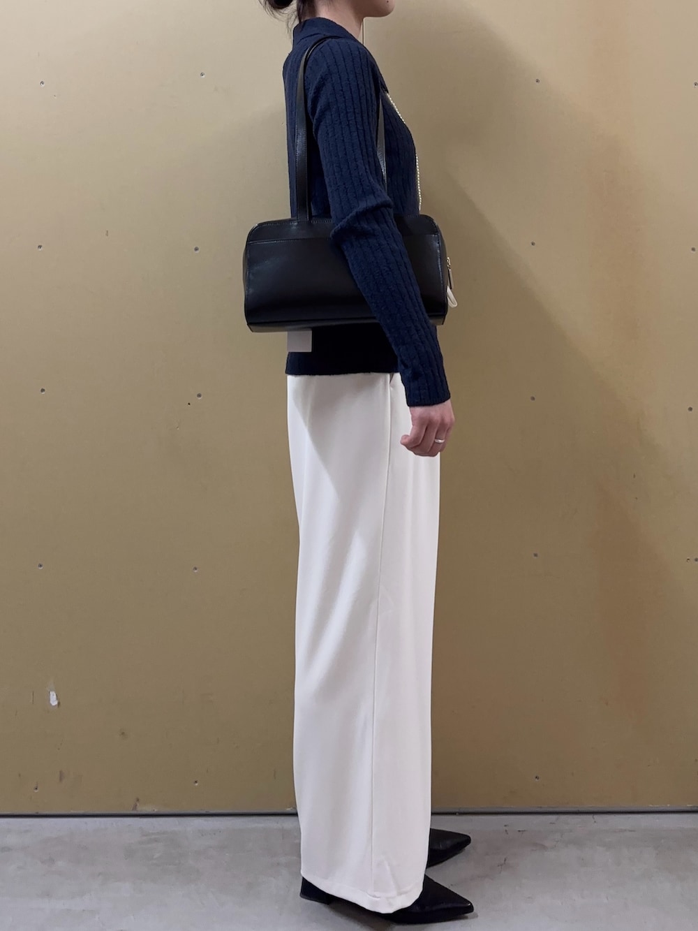 ホワイト系のその他パンツ、ブルー系のニット/セーター、ブラック系のショルダーバッグを着用したレディースの春コーディネートの2枚目の写真