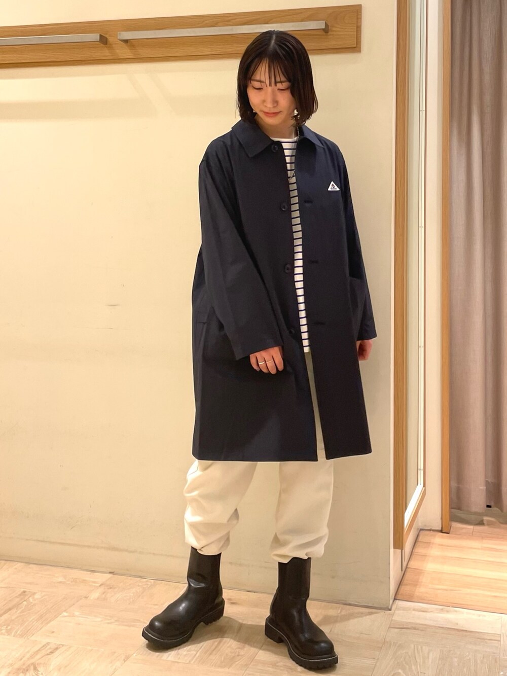 ブルー系のステンカラーコート、ブルー系のTシャツ/カットソー、ホワイト系のその他パンツを着用したレディースの春コーディネートの2枚目の写真
