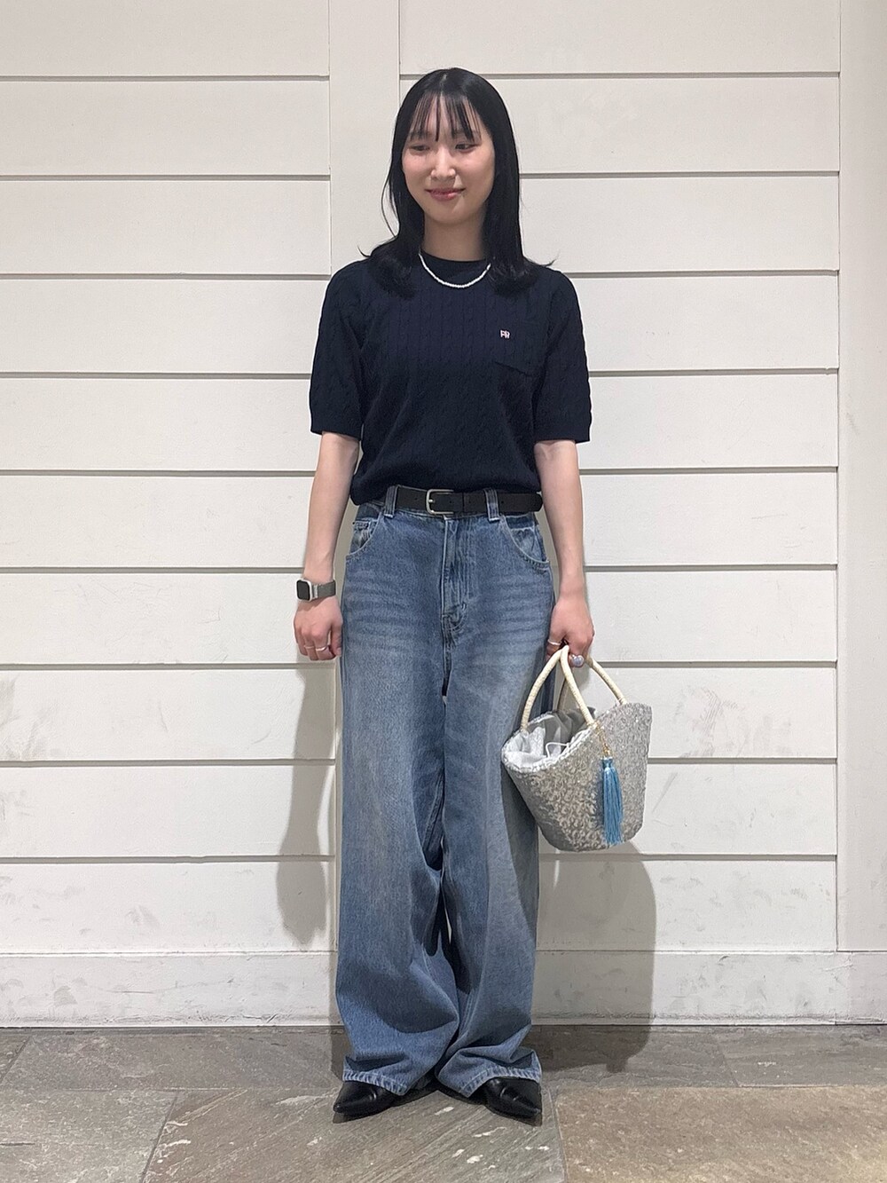 ブルー系のデニムパンツ、シルバー系のかごバッグ、ブルー系のニット/セーターを着用したレディースの春コーディネートの4枚目の写真