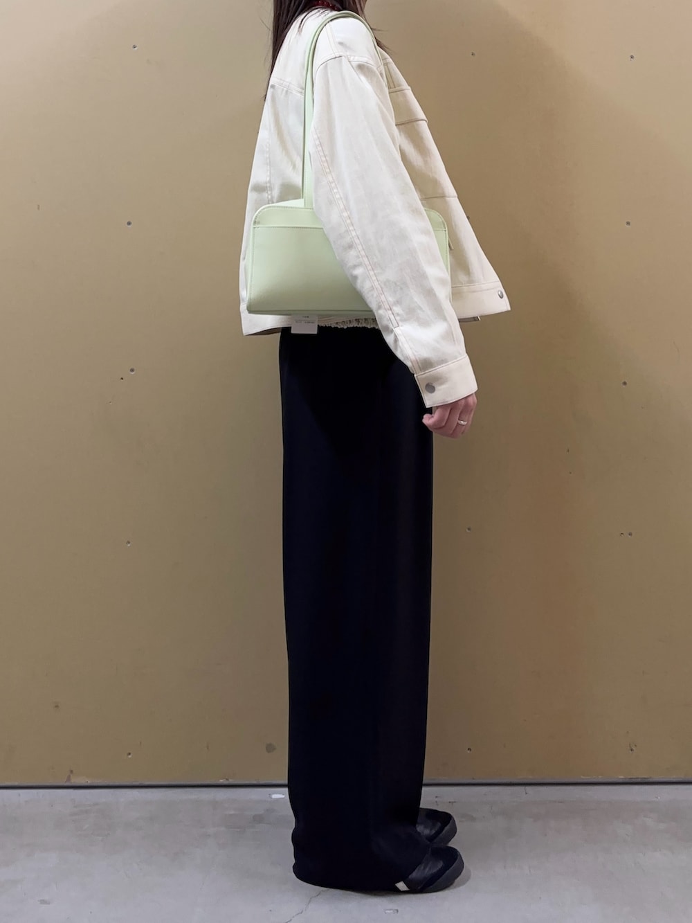 ベージュ系のニット/セーター、ホワイト系のノーカラージャケット、ブラック系のその他パンツを着用したレディースの春コーディネートの2枚目の写真