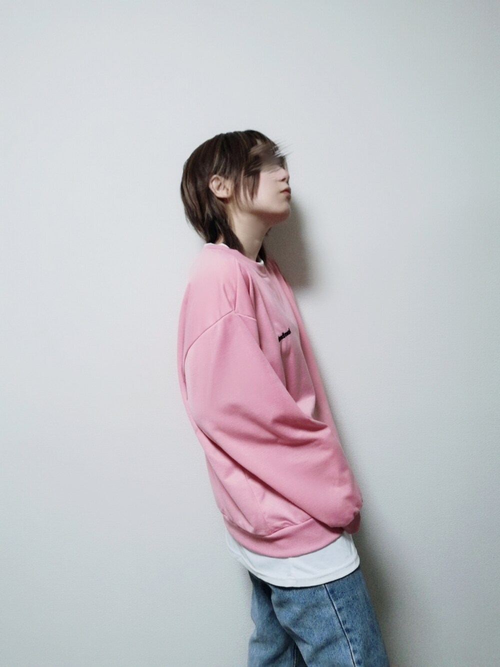 ピンク系のスウェット、ブルー系のデニムパンツを着用したレディースの冬コーディネートの3枚目の写真