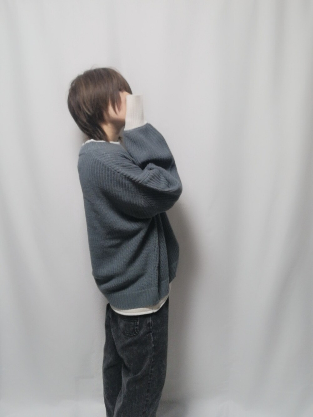 ブルー系のニット/セーター、ブラック系のデニムパンツを着用したレディースの冬コーディネートの2枚目の写真