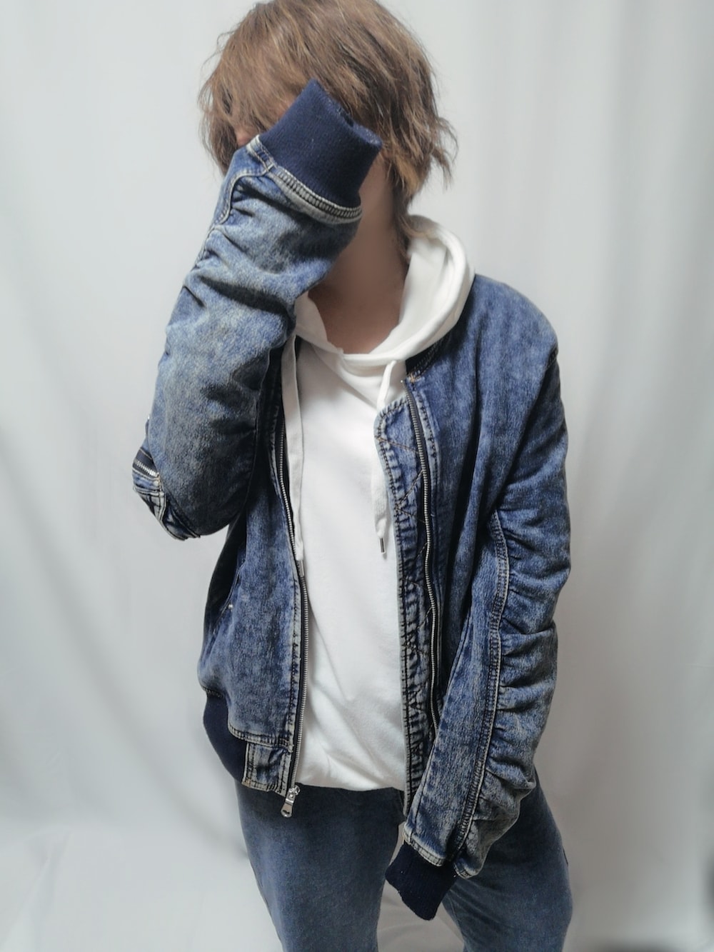 ブルー系のデニムパンツ、ホワイト系のパーカー、ブルー系のブルゾンを着用したレディースの冬コーディネートの2枚目の写真