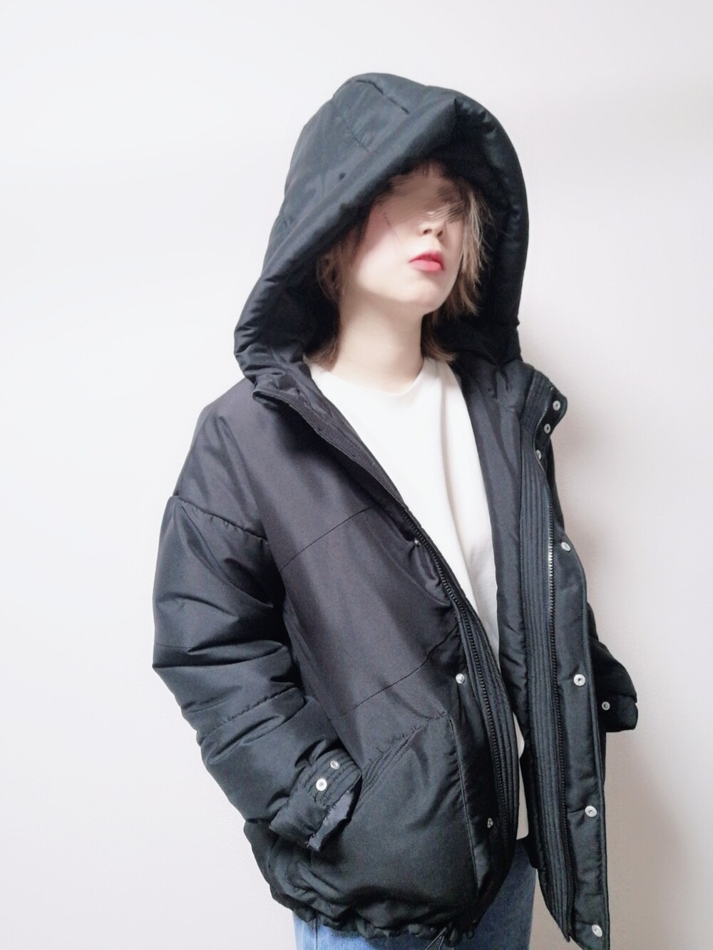 ブルー系のデニムパンツ、ブラック系のダウンジャケット/コートを着用したレディースの冬コーディネートの2枚目の写真