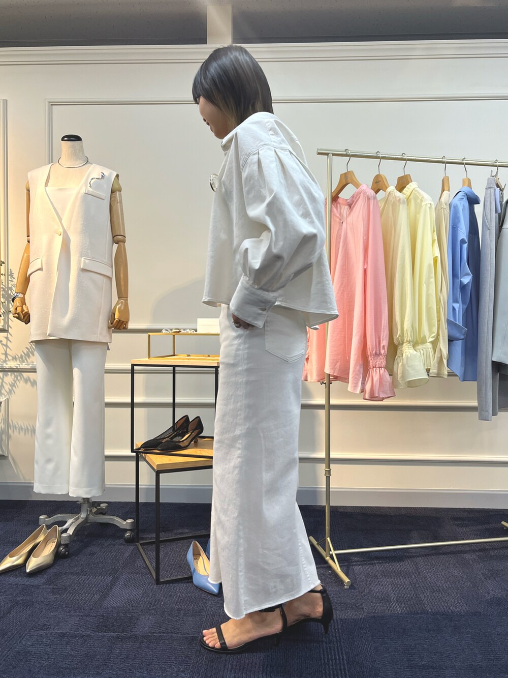 ホワイト系のシャツ/ブラウス、ホワイト系のデニムスカート、ブラック系のサンダルを着用したレディースの夏コーディネートの2枚目の写真