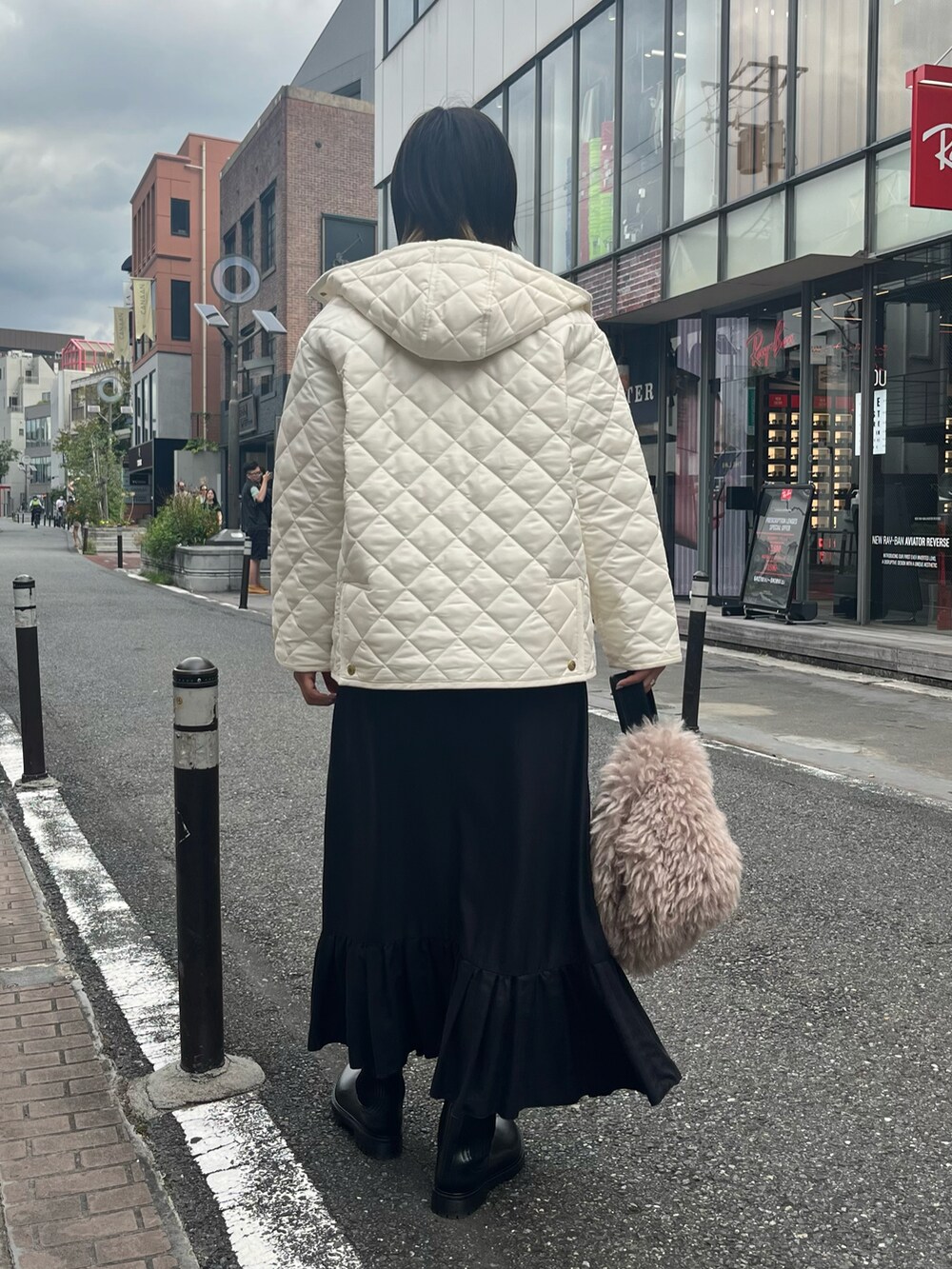 ホワイト系のブルゾン、ブラック系のTシャツ/カットソー、ブラック系のスカートを着用したレディースの秋コーディネートの5枚目の写真