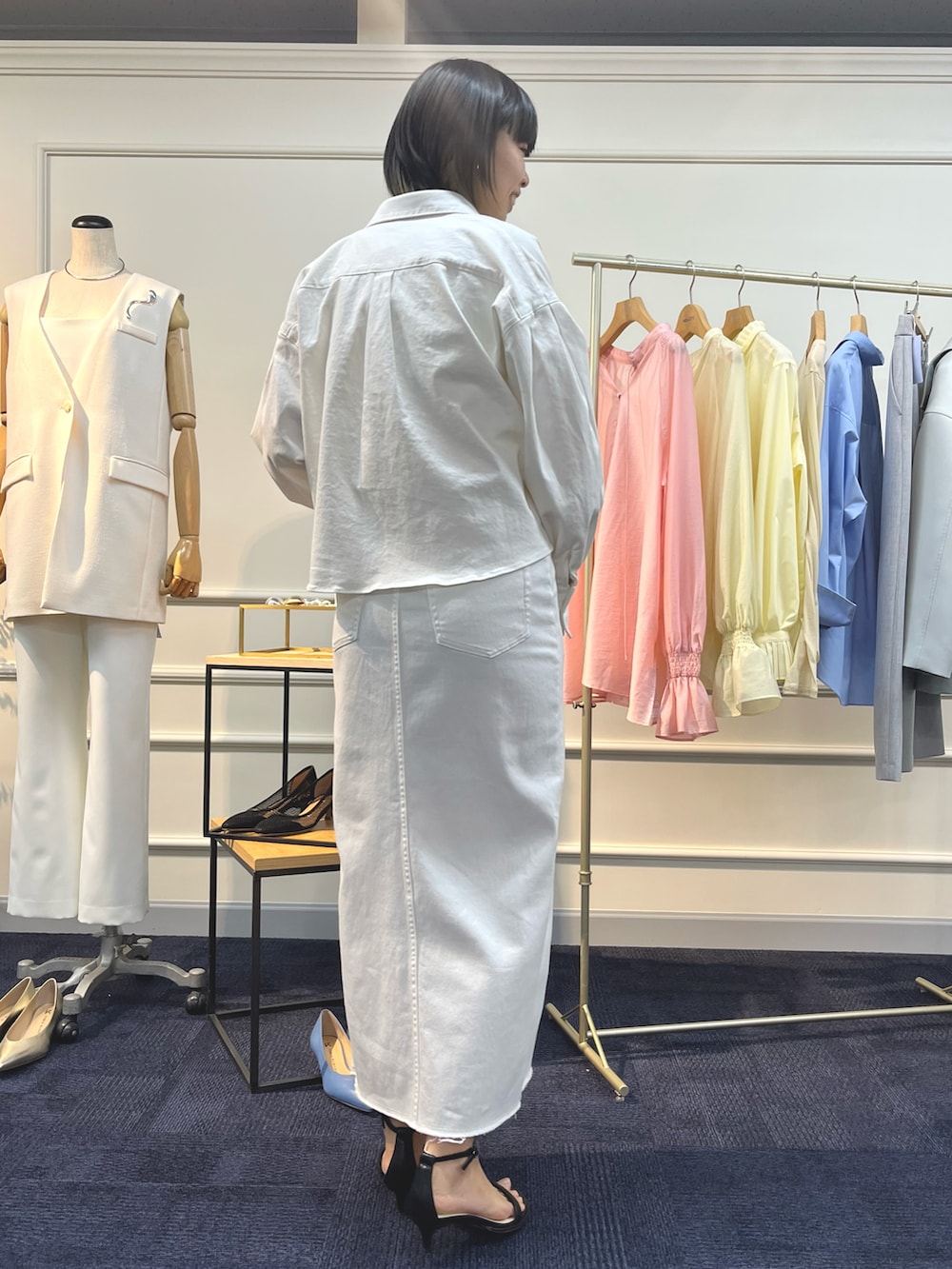 ホワイト系のシャツ/ブラウス、ホワイト系のデニムスカート、ブラック系のサンダルを着用したレディースの夏コーディネートの5枚目の写真