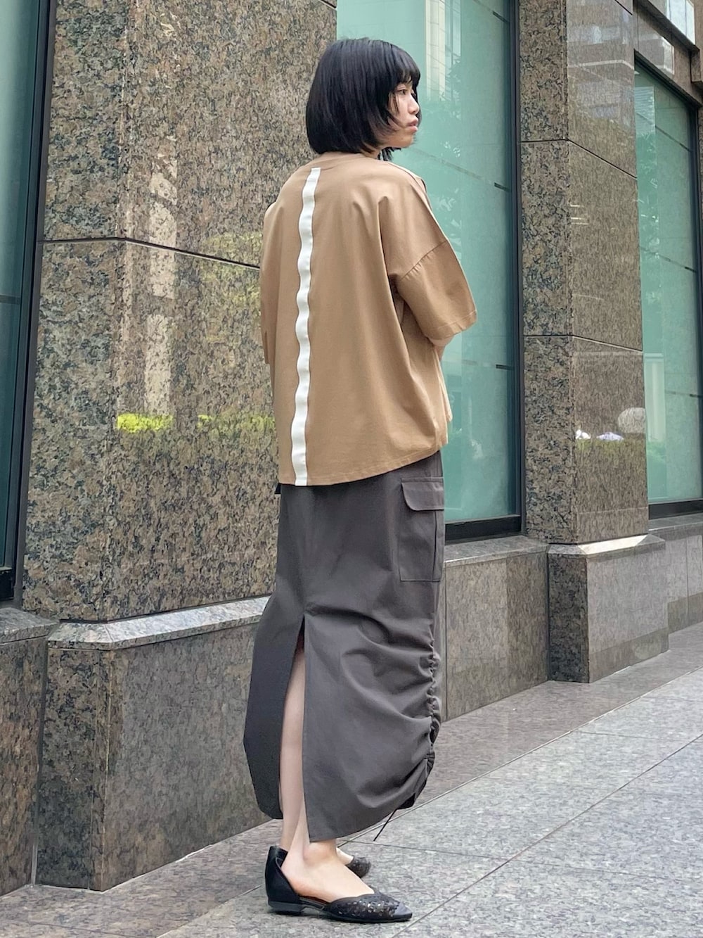 ブラウン系のTシャツ/カットソー、グレー系のスカートを着用したレディースの春コーディネートの2枚目の写真