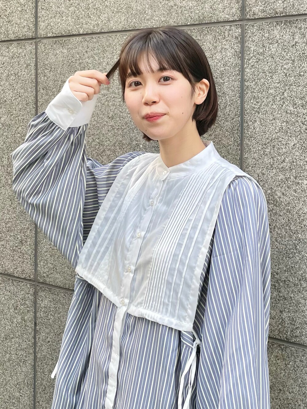 ブルー系のワンピース、グレー系のスニーカー、ブルー系の長傘を着用したレディースの春コーディネートの2枚目の写真