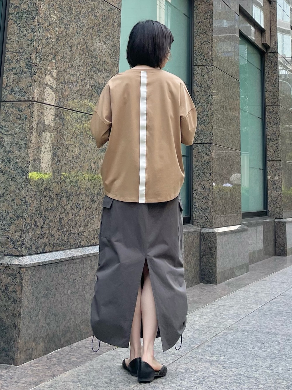 ブラウン系のTシャツ/カットソー、グレー系のスカートを着用したレディースの春コーディネートの3枚目の写真