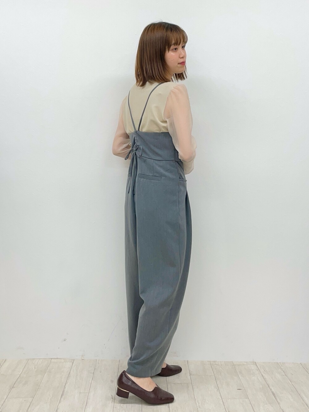 グレー系のサロペット/オーバーオール、ベージュ系のTシャツ/カットソーを着用したレディースの冬コーディネートの2枚目の写真