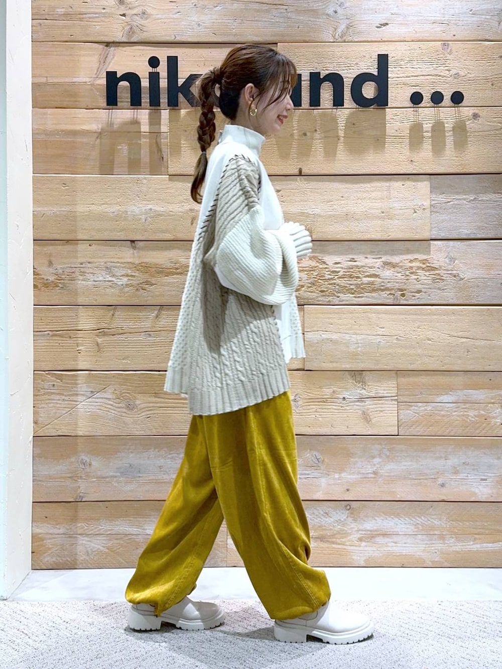 ベージュ系のブーツ、イエロー系のカーゴパンツ、ホワイト系のニット/セーターを着用したレディースの秋コーディネートの6枚目の写真