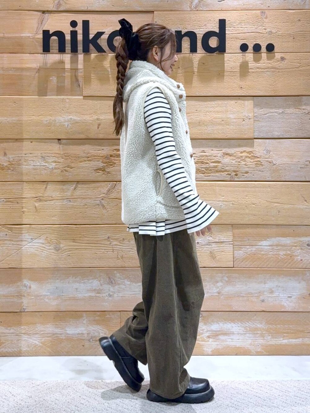 ベージュ系のダウンベスト、ベージュ系のニット/セーター、ブラック系のドレスシューズを着用したレディースの秋コーディネートの5枚目の写真