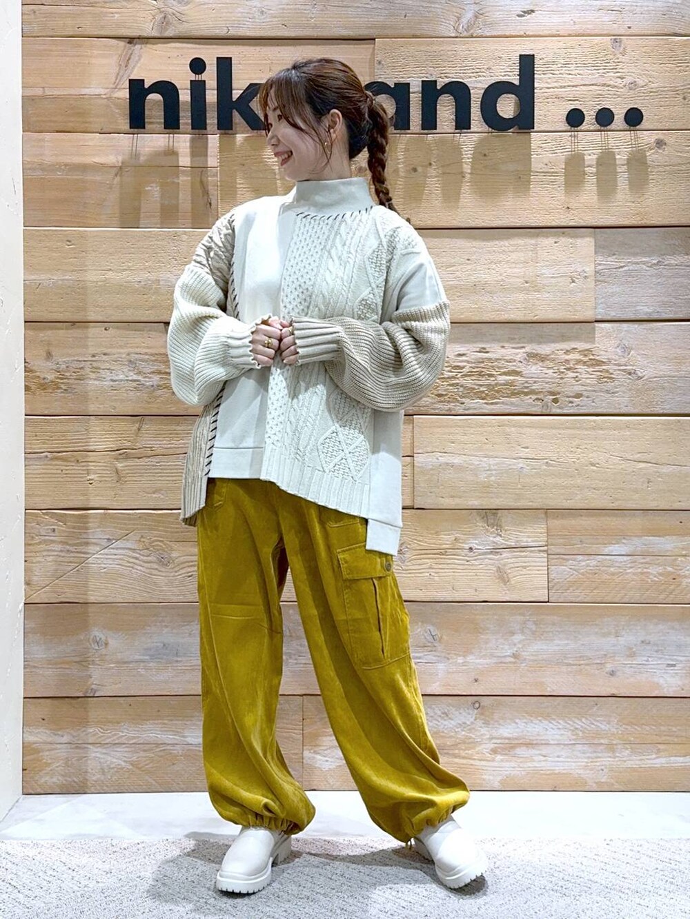 ベージュ系のブーツ、イエロー系のカーゴパンツ、ホワイト系のニット/セーターを着用したレディースの秋コーディネートの4枚目の写真