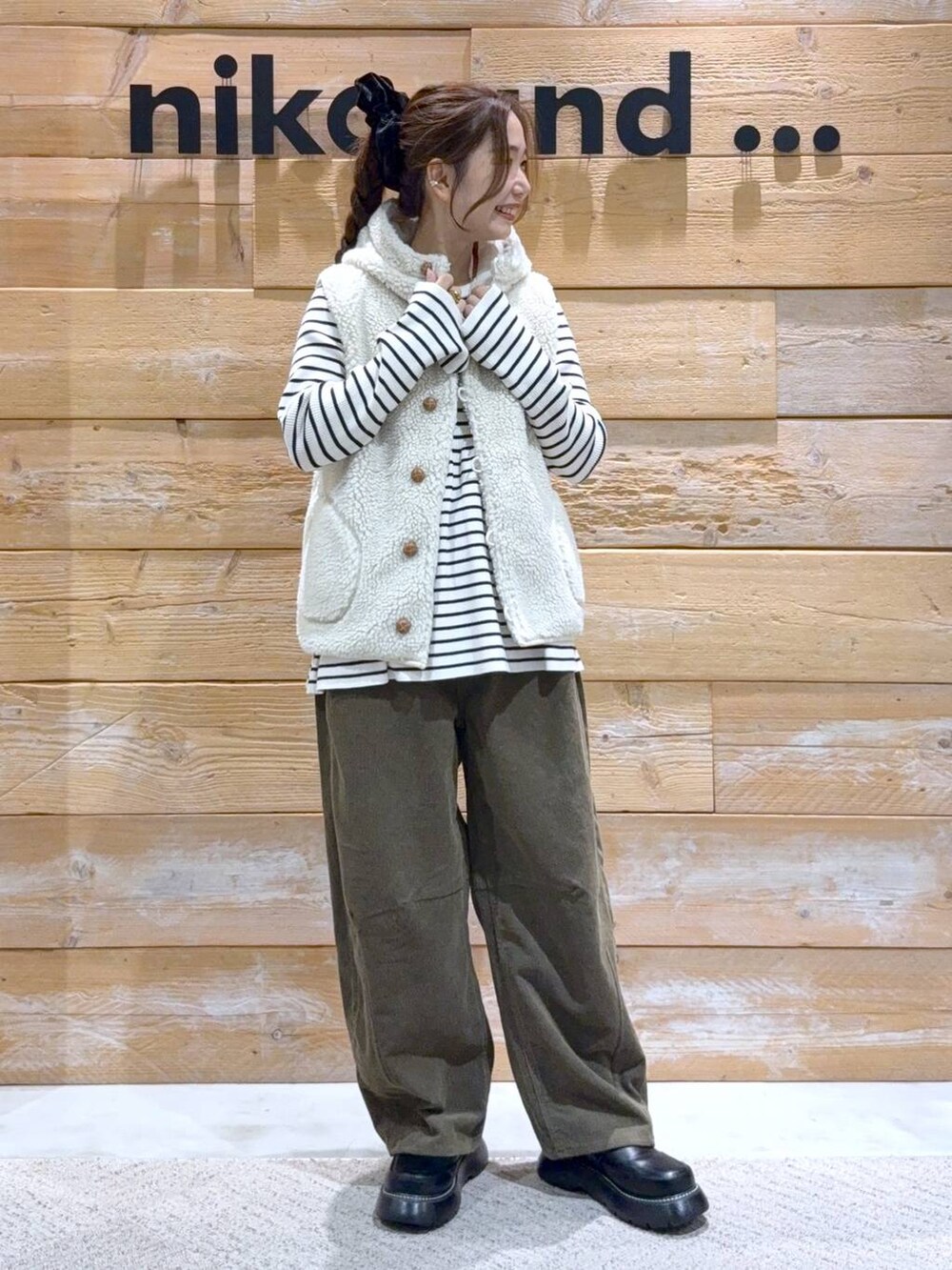 ベージュ系のダウンベスト、ベージュ系のニット/セーター、ブラック系のドレスシューズを着用したレディースの秋コーディネートの3枚目の写真