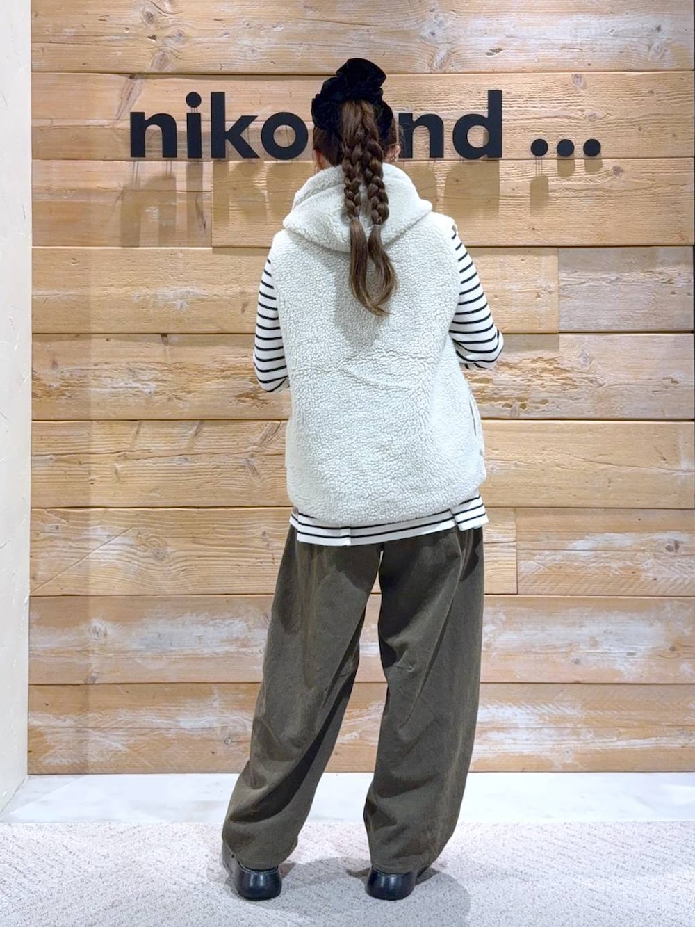 ベージュ系のダウンベスト、ベージュ系のニット/セーター、ブラック系のドレスシューズを着用したレディースの秋コーディネートの6枚目の写真