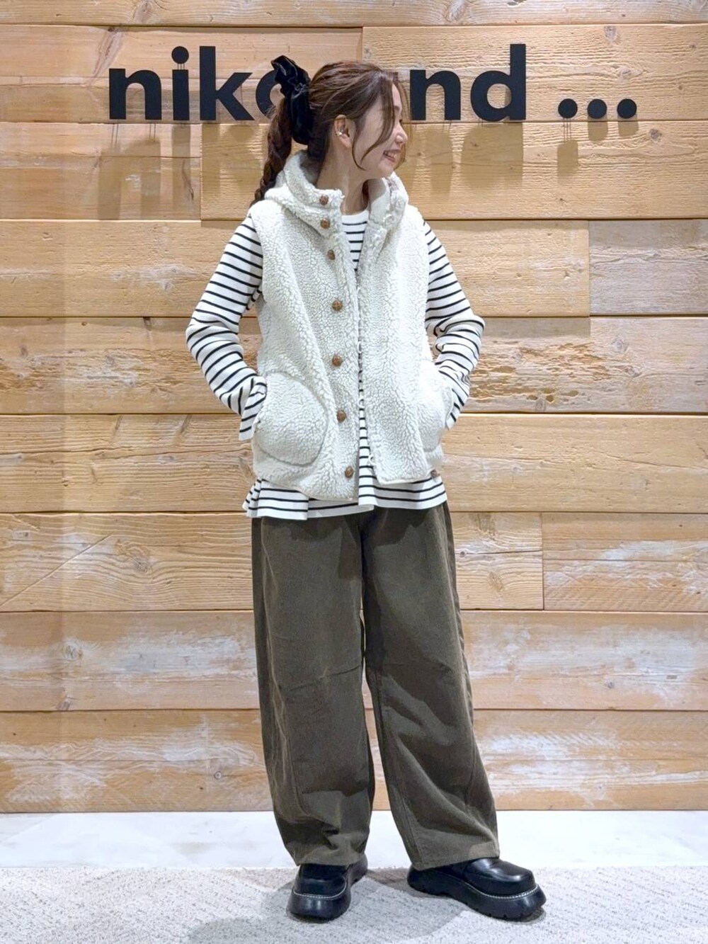 ベージュ系のダウンベスト、ベージュ系のニット/セーター、ブラック系のドレスシューズを着用したレディースの秋コーディネートの2枚目の写真