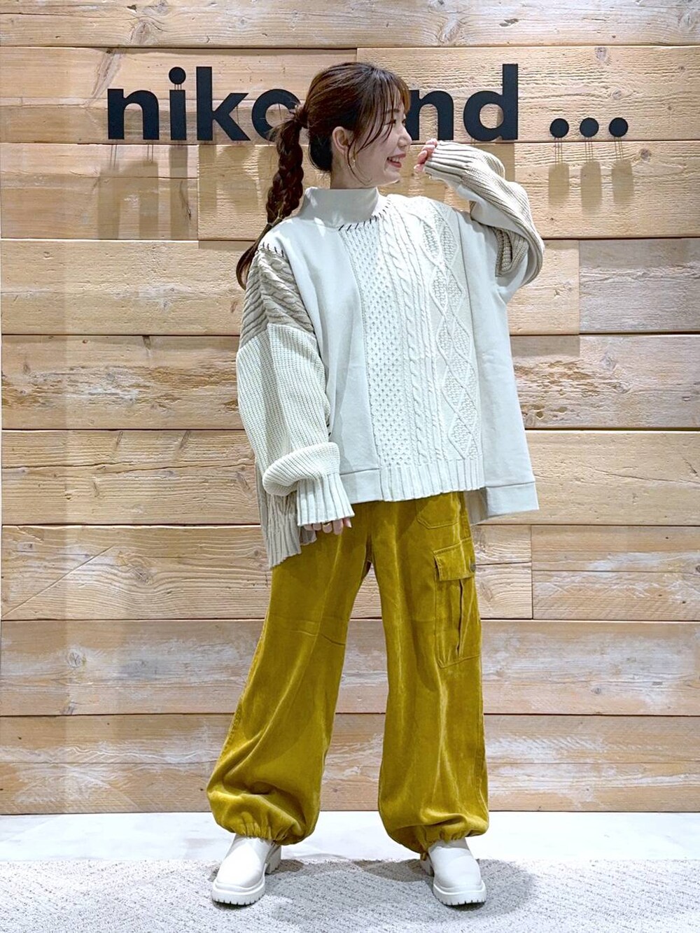 ベージュ系のブーツ、イエロー系のカーゴパンツ、ホワイト系のニット/セーターを着用したレディースの秋コーディネートの2枚目の写真