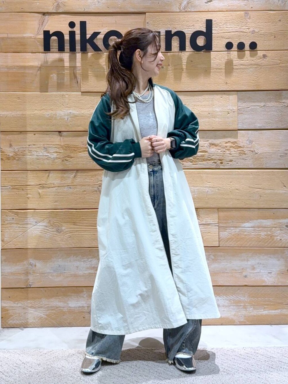 ベージュ系のワンピース、シルバー系のパンプス、ブルー系のその他パンツを着用したレディースの冬コーディネートの3枚目の写真