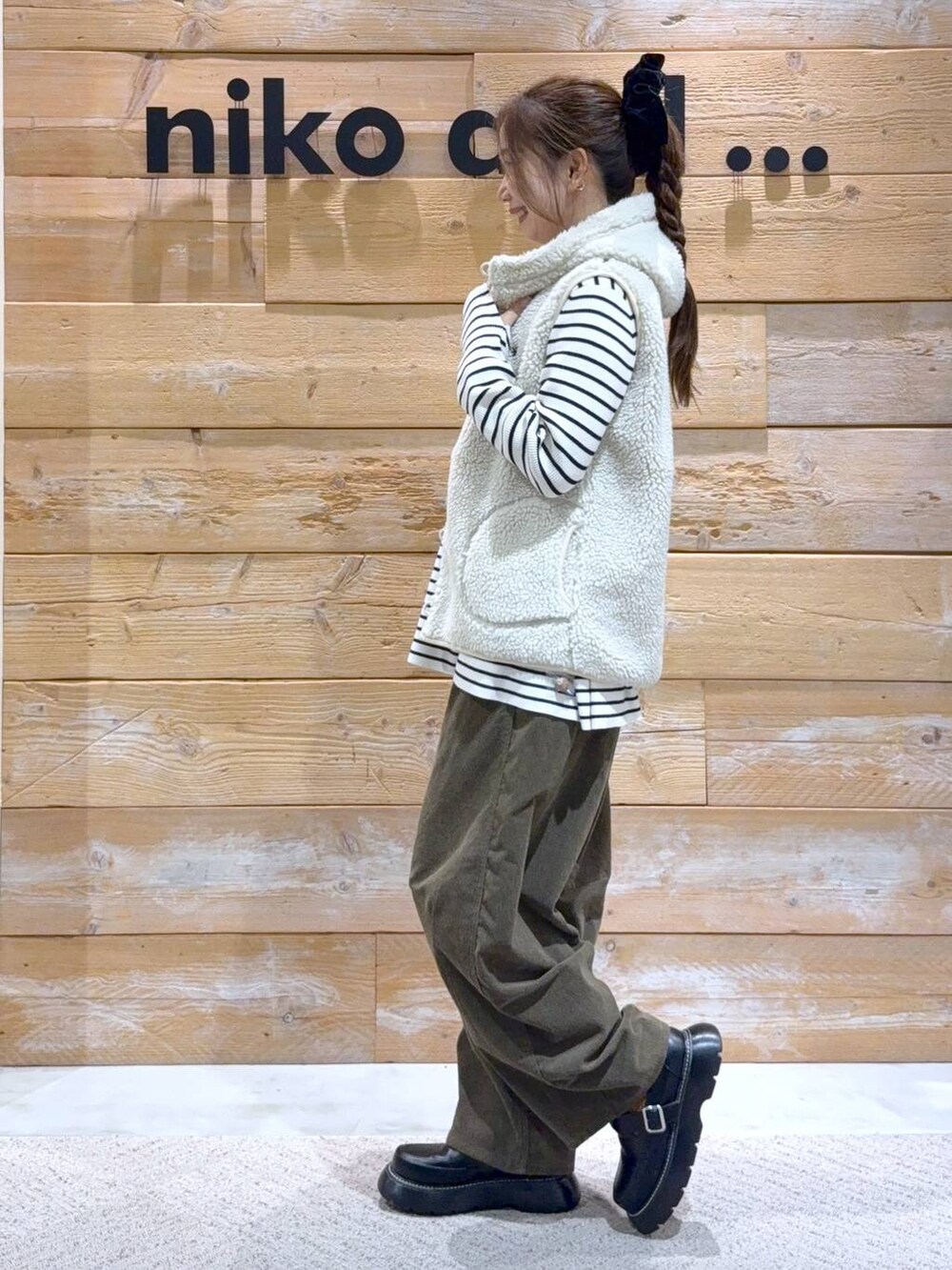 ベージュ系のダウンベスト、ベージュ系のニット/セーター、ブラック系のドレスシューズを着用したレディースの秋コーディネートの4枚目の写真