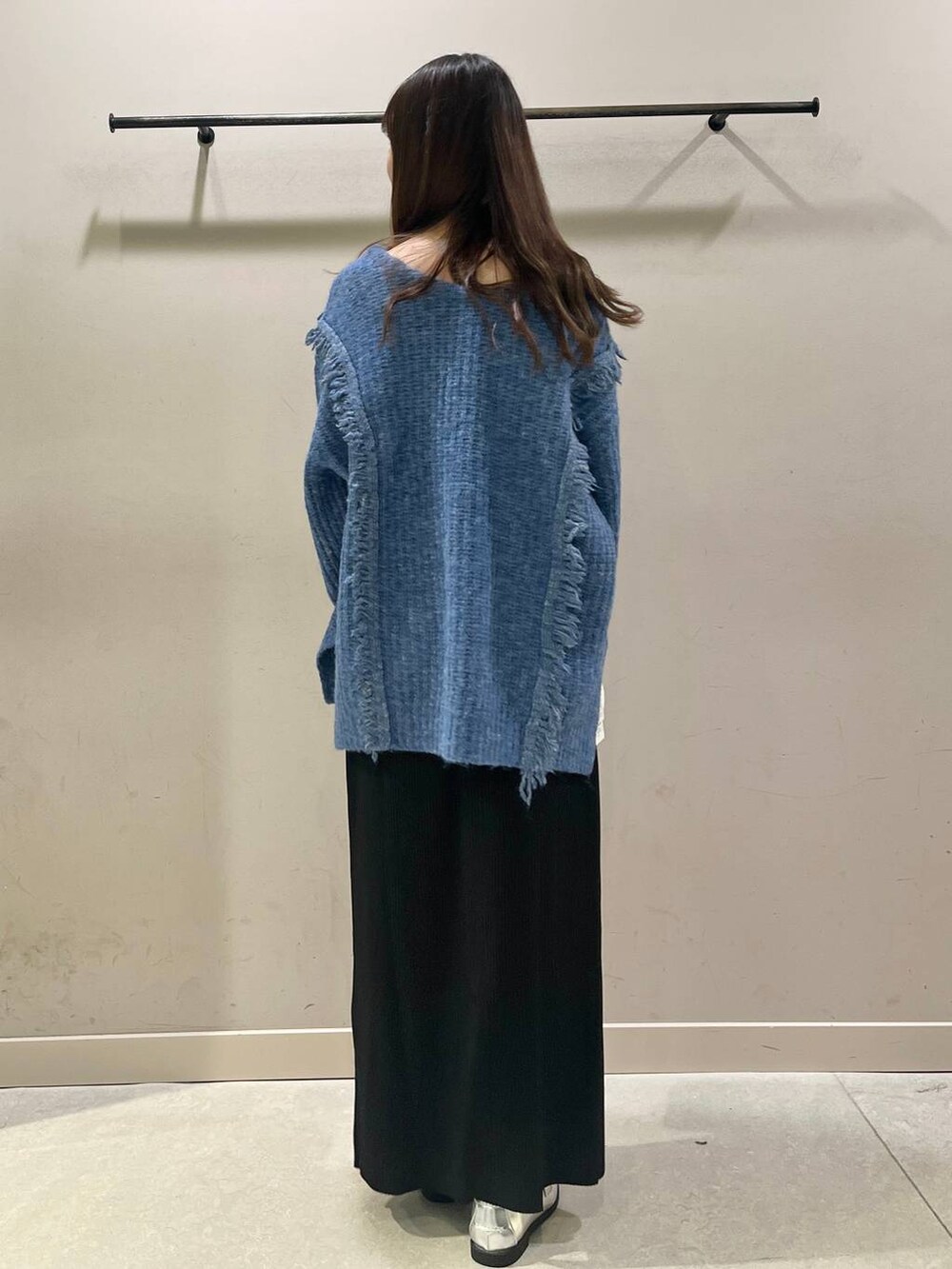 ブラック系のスカート、シルバー系のローファー、ブルー系のニット/セーターを着用したレディースの秋コーディネートの2枚目の写真