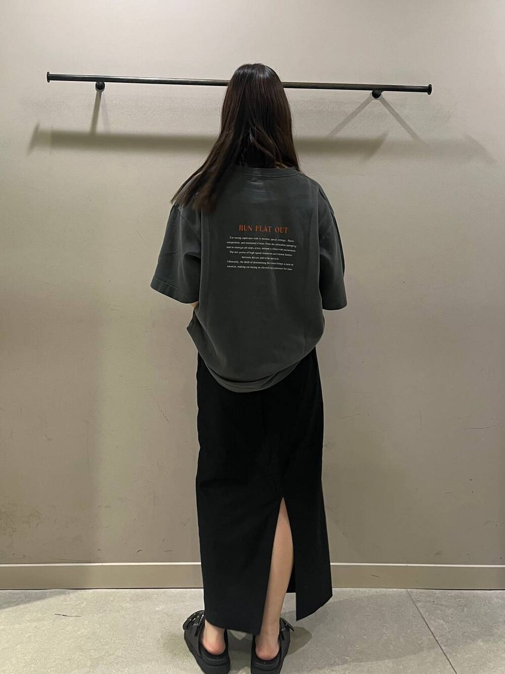 ブラック系のスカート、グレー系のTシャツ/カットソー、ブラック系のショルダーバッグを着用したレディースの夏コーディネートの2枚目の写真
