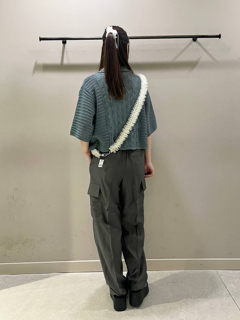 シルバー系のサンダル、グレー系のカーゴパンツ、グリーン系のニット/セーターを着用したレディースの夏コーディネートの2枚目の写真