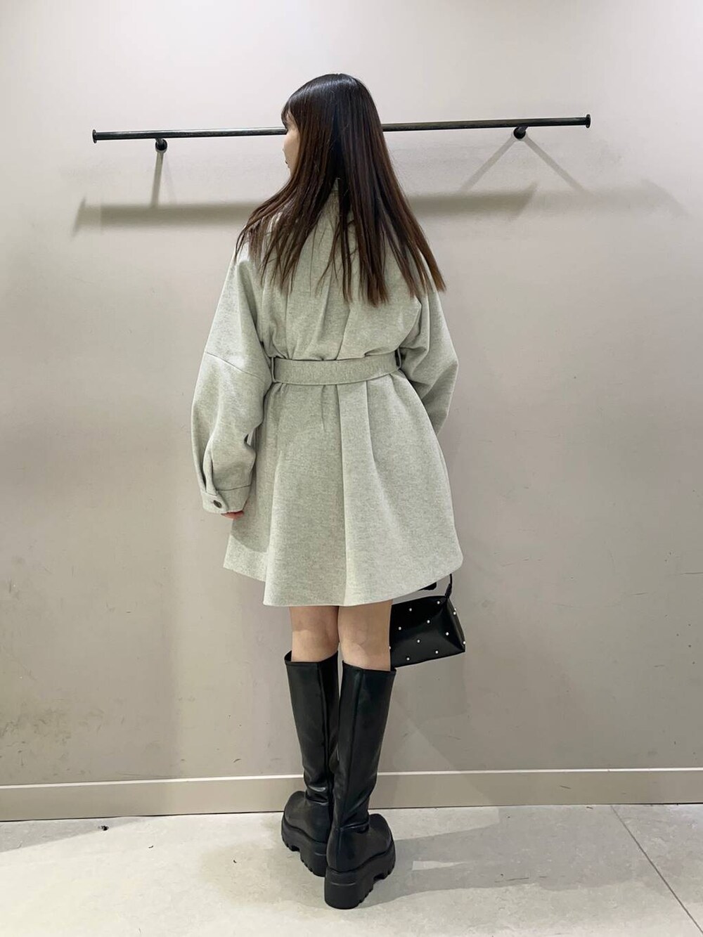 グレー系のその他アウター、ブラック系のブーツ、レッド系のニット/セーターを着用したレディースの秋コーディネートの2枚目の写真