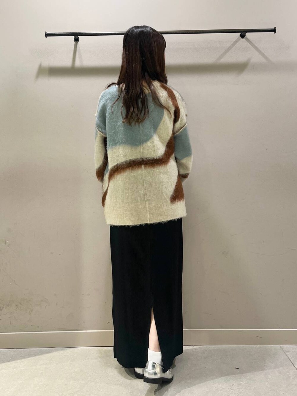 ブラック系のスカート、シルバー系のローファー、シルバー系のボストンバッグを着用したレディースの秋コーディネートの2枚目の写真