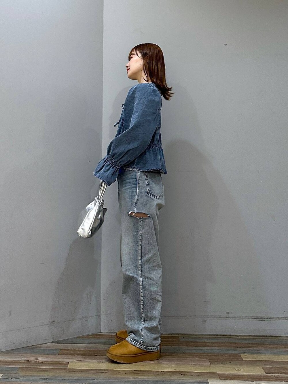 ブルー系のデニムパンツ、ブルー系のシャツ/ブラウス、ブラウン系のブーツを着用したレディースの冬コーディネートの2枚目の写真