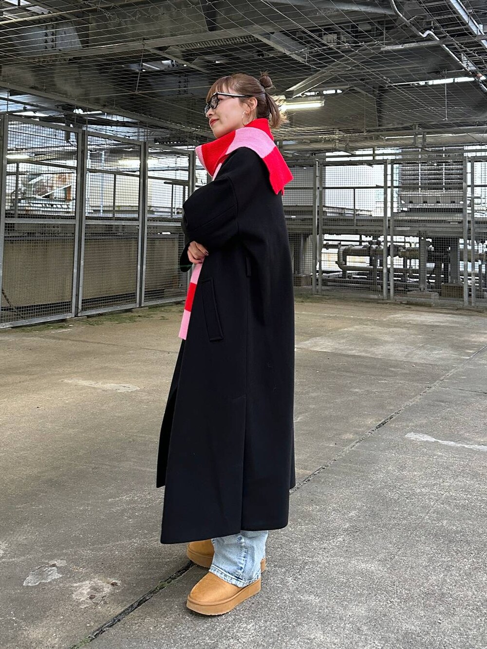 ブラック系のトレンチコート、ブルー系のデニムパンツ、グレー系のスウェットを着用したレディースの冬コーディネートの3枚目の写真