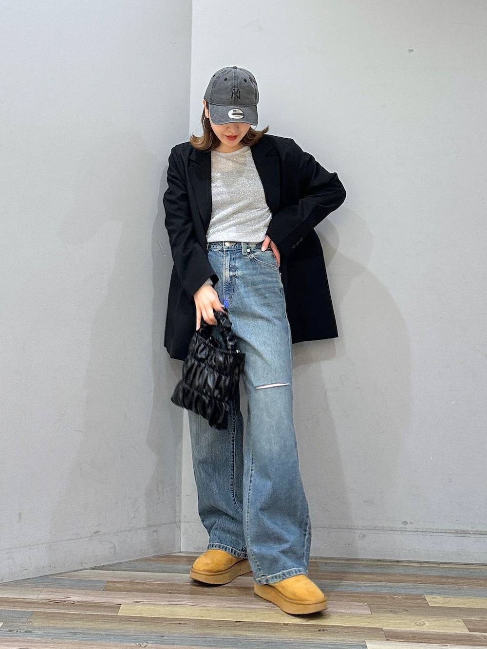 ブラウン系のブーツ、ブルー系のデニムパンツ、ブラック系のショルダーバッグを着用したレディースの冬コーディネートの4枚目の写真