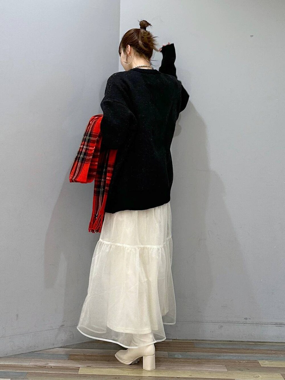 ホワイト系のパンプス、ホワイト系のスカート、ブラック系のニット/セーターを着用したレディースの冬コーディネートの3枚目の写真