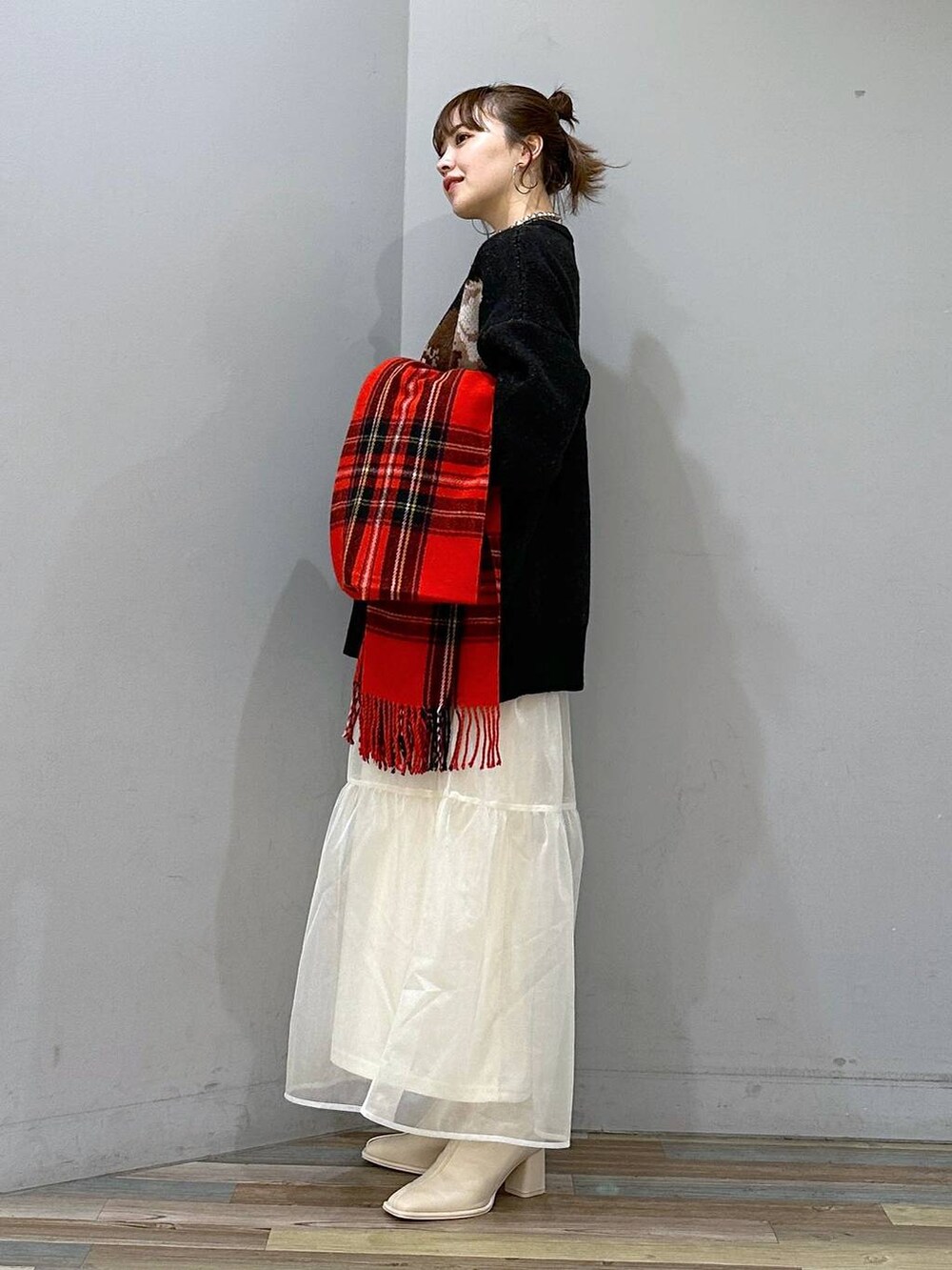 ホワイト系のパンプス、ホワイト系のスカート、ブラック系のニット/セーターを着用したレディースの冬コーディネートの2枚目の写真