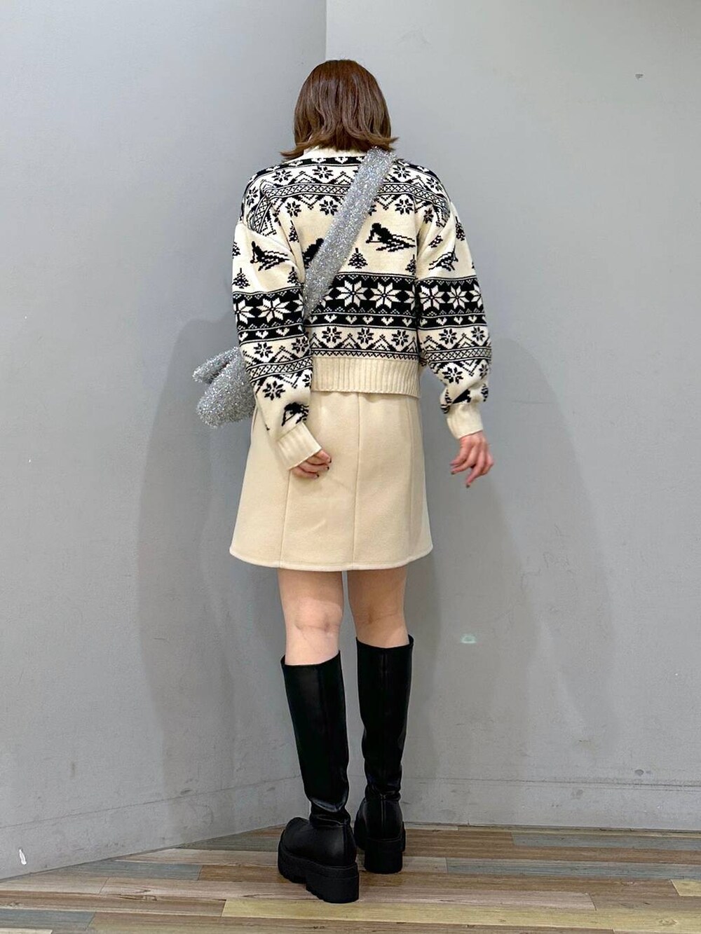 ベージュ系のニット/セーター、ブラック系のブーツ、ホワイト系のスカートを着用したレディースの秋コーディネートの3枚目の写真