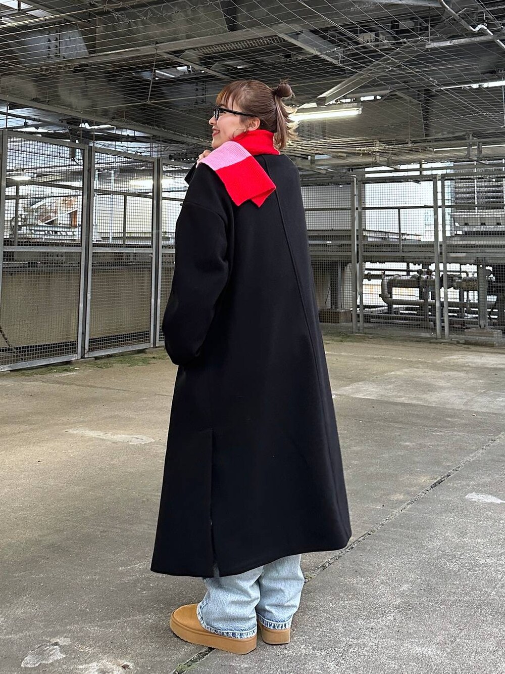 ブラック系のトレンチコート、ブルー系のデニムパンツ、グレー系のスウェットを着用したレディースの冬コーディネートの2枚目の写真