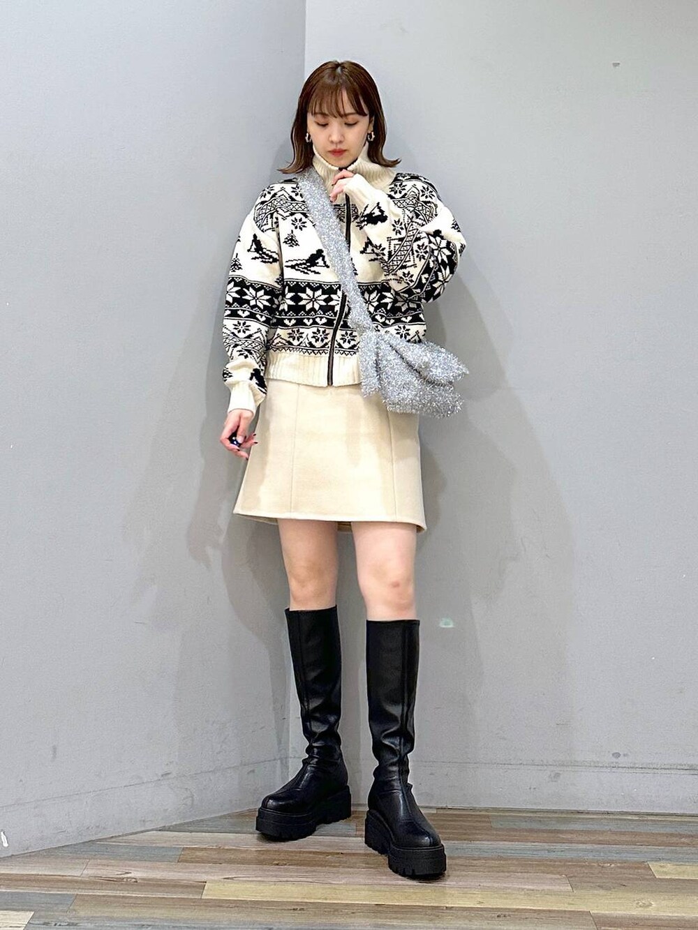 ベージュ系のニット/セーター、ブラック系のブーツ、ホワイト系のスカートを着用したレディースの秋コーディネートの4枚目の写真