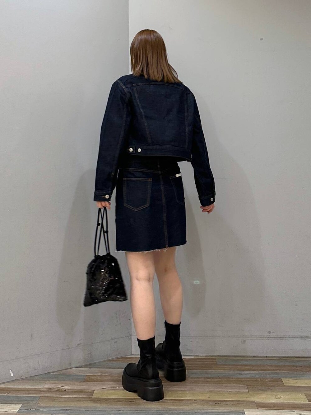 ブラック系のブーツ、ブラック系のハンドバッグ、ブラック系のTシャツ/カットソーを着用したレディースの冬コーディネートの3枚目の写真