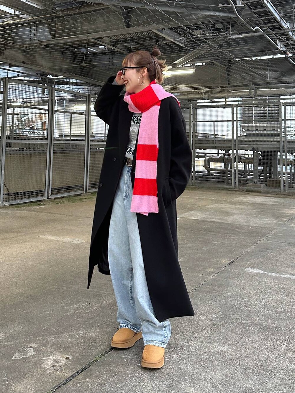 ブラック系のトレンチコート、ブルー系のデニムパンツ、グレー系のスウェットを着用したレディースの冬コーディネートの4枚目の写真