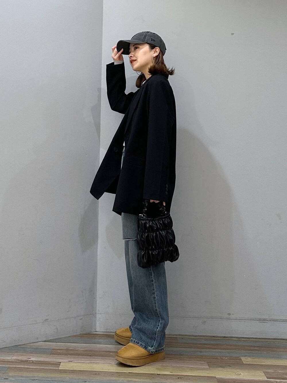 ブラウン系のブーツ、ブルー系のデニムパンツ、ブラック系のショルダーバッグを着用したレディースの冬コーディネートの2枚目の写真