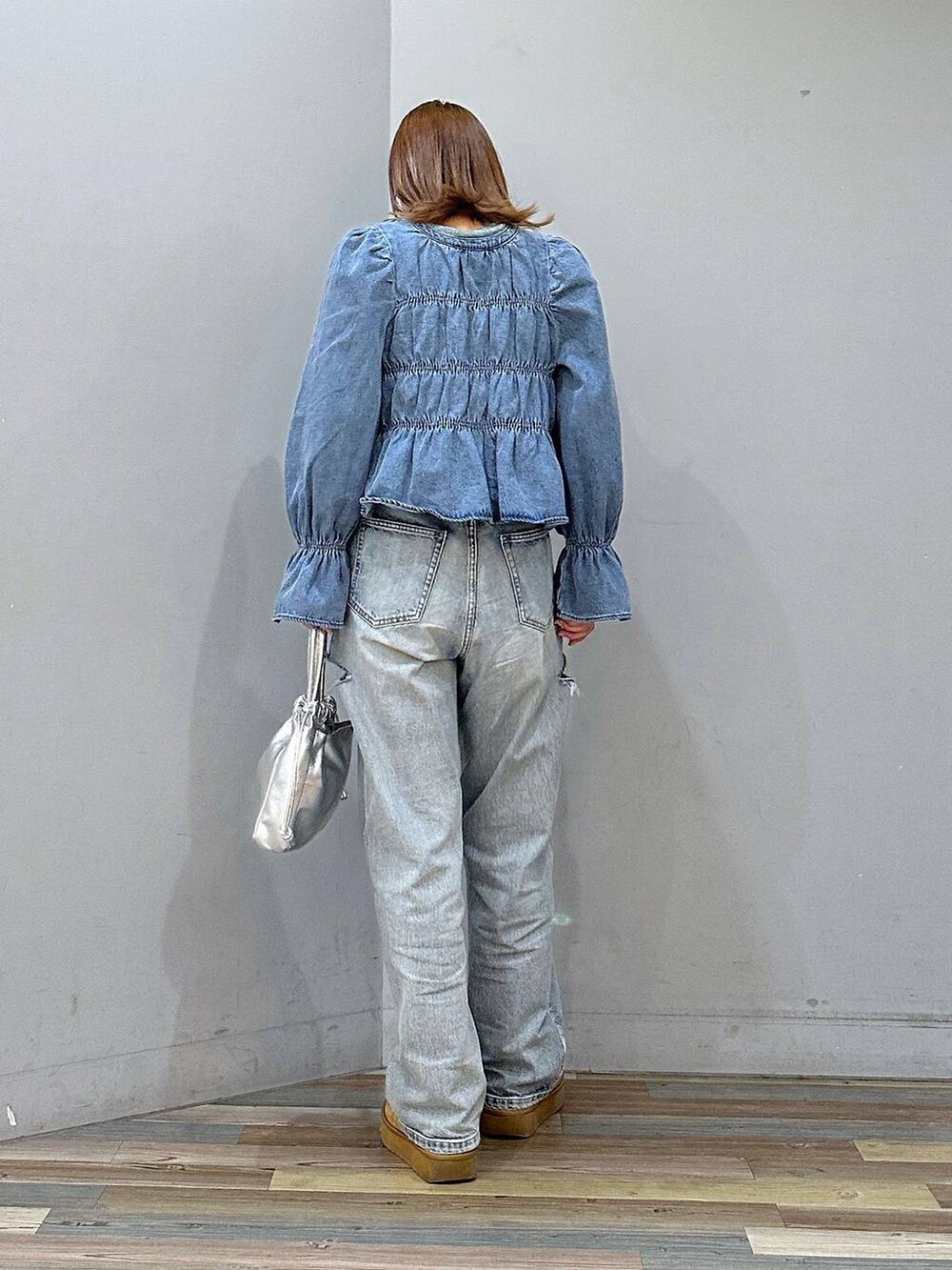 ブルー系のデニムパンツ、ブルー系のシャツ/ブラウス、ブラウン系のブーツを着用したレディースの冬コーディネートの3枚目の写真