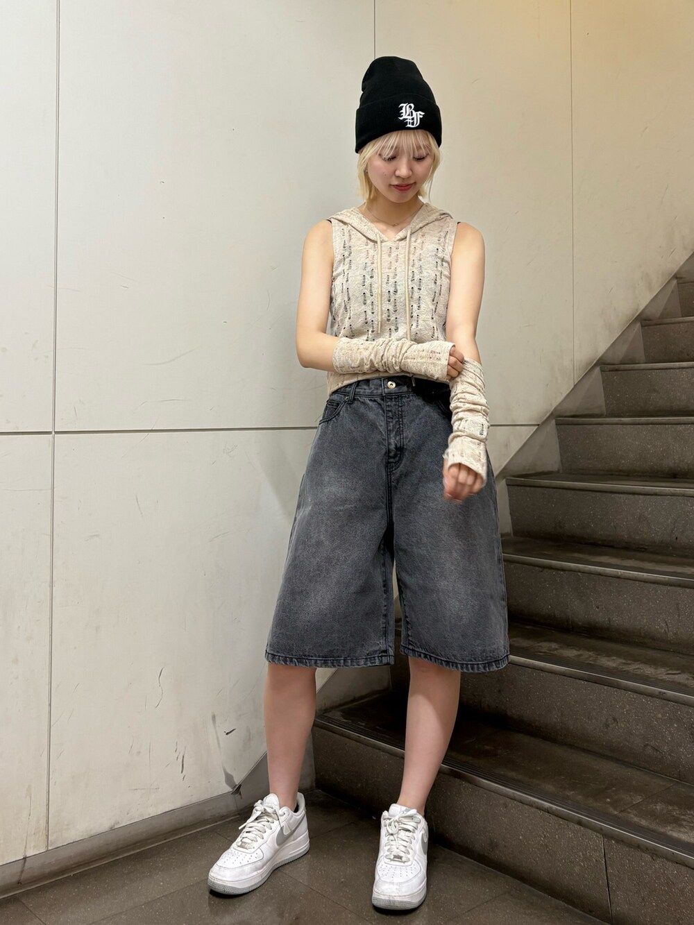 ブラック系のデニムパンツ、ベージュ系のニット/セーター、ブラック系のニットキャップ/ビーニーを着用したレディースの春コーディネートの2枚目の写真