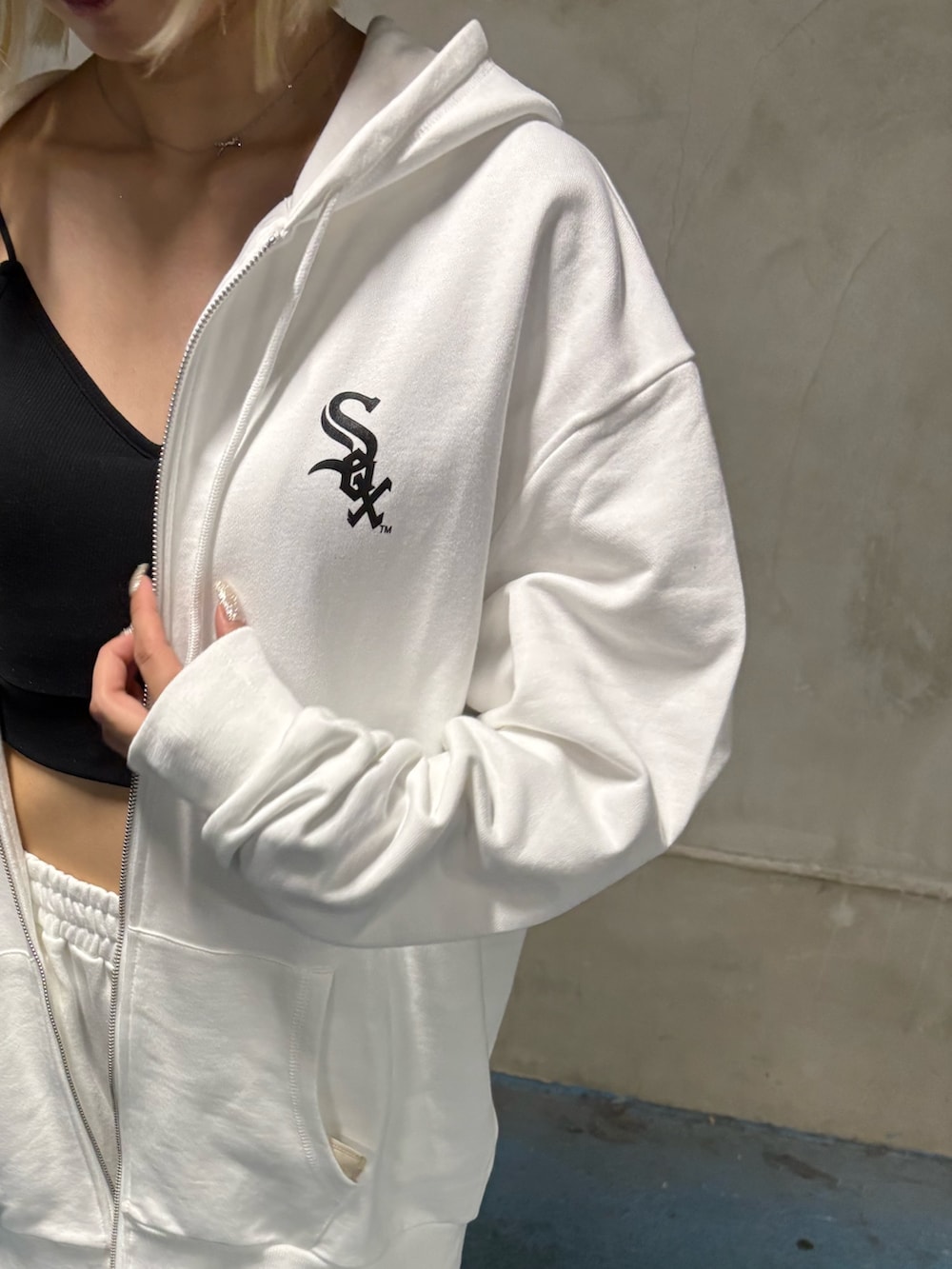 ホワイト系のワンピース、ブラック系のブーツを着用したレディースの夏コーディネートの3枚目の写真